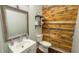 Bathroom featuring a vanity with a decorative mirror and a wood-paneled accent wall at 2144 Beacon Crest Drive, Buford, GA 30519