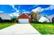 Traditional two-story home with lush green lawn and driveway leading to a garage at 2144 Beacon Crest Drive, Buford, GA 30519