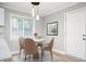 Bright dining area featuring a modern light fixture, a round table with seating for four, and a door at 2198 Star Mist Sw Dr, Atlanta, GA 30311