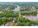 Expansive aerial view showcases the neighborhood's lush greenery, community pool, and the serene lake at 2325 Walnut Grove Way, Suwanee, GA 30024