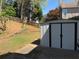Image shows a backyard shed and concrete patio with grassy area, and retaining wall at 2325 Walnut Grove Way, Suwanee, GA 30024