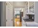 Hallway view leading to a modern kitchen with stainless steel appliances and sleek cabinetry at 2325 Walnut Grove Way, Suwanee, GA 30024