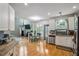 Bright kitchen featuring wooden floors, stainless steel appliances and adjacent living space with dining area at 2325 Walnut Grove Way, Suwanee, GA 30024