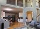 Spacious living room with high ceilings that show railings and opens into kitchen with stainless steel appliances at 2325 Walnut Grove Way, Suwanee, GA 30024