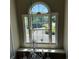 Arched window with a view of a landscaped neighborhood featuring a hanging chandelier at 2325 Walnut Grove Way, Suwanee, GA 30024