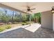 Spacious covered back patio features stone flooring, ceiling fan, and views of the lush backyard landscaping at 3709 Baxley Ridge Dr, Suwanee, GA 30024