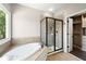 Bathroom with glass-enclosed shower, soaking tub, and access to a walk-in closet at 3709 Baxley Ridge Dr, Suwanee, GA 30024