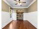 Versatile bonus room features hardwood floors, a stone accent wall with shelves, and white shiplap wainscoting at 3709 Baxley Ridge Dr, Suwanee, GA 30024