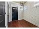 Foyer featuring dark front door, floral wallpaper, hardwood flooring, and natural light from clerestory windows at 3709 Baxley Ridge Dr, Suwanee, GA 30024