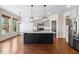 Open kitchen boasts a large center island, stainless steel appliances, pendant lighting, and hardwood floors at 3709 Baxley Ridge Dr, Suwanee, GA 30024