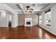 Bright living room with hardwood floors, brick fireplace, large windows, and coffered ceiling with ceiling fan at 3709 Baxley Ridge Dr, Suwanee, GA 30024