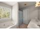 Bright bathroom with a soaking tub, double vanity, and shower with a patterned curtain at 7665 Golden Sands Dr, Cumming, GA 30041