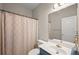 Well-lit bathroom featuring a single sink with a marble countertop and patterned shower curtain at 7665 Golden Sands Dr, Cumming, GA 30041
