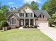Charming two-story home featuring brick accents, a manicured lawn, and an attached two-car garage at 7665 Golden Sands Dr, Cumming, GA 30041