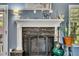 Living room fireplace with stone surround, decorative mantel and screen, and nearby guitar at 12 Little Creek Manor Dr, Dallas, GA 30157