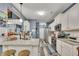 A modern kitchen features white cabinets, stainless steel appliances, granite countertops, and a peninsula with barstool seating at 12 Little Creek Manor Dr, Dallas, GA 30157