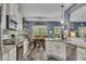 The kitchen features stainless steel appliances, ample counter space, white cabinetry, and an easy transition to the dining area at 12 Little Creek Manor Dr, Dallas, GA 30157