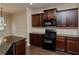 Kitchen featuring black appliances, dark wood cabinetry, and a view of the breakfast nook at 142 Susie Creek Ln, Villa Rica, GA 30180