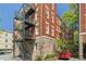Building exterior featuring exposed brick, private exterior staircase and lovely landscaping at 20 Collier Nw Rd # 11, Atlanta, GA 30309