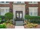 Elegant building entrance with manicured landscaping, detailed stonework, and classic lanterns at 20 Collier Nw Rd # 11, Atlanta, GA 30309