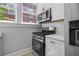Charming kitchen featuring stainless steel oven, microwave and refrigerator, quartz countertop, and white cabinetry at 20 Collier Nw Rd # 11, Atlanta, GA 30309