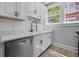 Bright kitchen features white cabinets, stainless steel dishwasher, modern faucet, and lovely window views at 20 Collier Nw Rd # 11, Atlanta, GA 30309