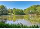 Picturesque view of a serene lake reflecting the surrounding landscape and bright blue sky at 2095 Southers Cir, Suwanee, GA 30024