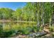 Calm pond reflecting surrounding lush greenery and trees with a small wooden dock at 2095 Southers Cir, Suwanee, GA 30024