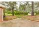 Spacious backyard featuring a detached garage/shed and mature trees, offering privacy and potential at 5032 Central Church Rd, Douglasville, GA 30135