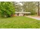 Charming brick home with a well-maintained lawn and covered carport, surrounded by mature trees at 5032 Central Church Rd, Douglasville, GA 30135