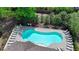 Aerial view of community pool surrounded by trees, lounge chairs, and a secure fence at 1372 Doublegate Dr, Atlanta, GA 30319