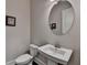 Powder room with pedestal sink, oval mirror, and toilet at 1372 Doublegate Dr, Atlanta, GA 30319