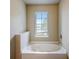 Bathroom featuring a soaking tub, window, and neutral colors at 2722 Sardis Chase Ct, Buford, GA 30519