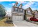 Lovely townhome featuring a two-car garage with a double wide driveway and attractive architectural details at 2722 Sardis Chase Ct, Buford, GA 30519