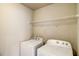 Convenient laundry room with a washer, dryer, and a wire storage shelf at 2722 Sardis Chase Ct, Buford, GA 30519