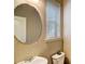 Cozy powder room features an oval mirror and natural light from the window at 2722 Sardis Chase Ct, Buford, GA 30519