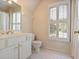 A bright white bathroom features tile floors, wooden cabinets and a large window with shutter-style blinds at 415 Westlake Nw Ct, Marietta, GA 30064