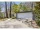 Modern home exterior with a large driveway and attached two-car garage, surrounded by lush greenery and mature trees at 1105 Crest Valley Dr, Sandy Springs, GA 30327