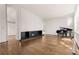 Bright living room with hardwood floors, a modern fireplace, and a grand piano near large windows at 1105 Crest Valley Dr, Sandy Springs, GA 30327