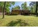 Spacious backyard with lush green lawn, mature trees, wooden fence, and access to the house at 1650 Randee Nw St, Atlanta, GA 30318