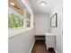 A hallway with hardwood floors, a built-in bench, and a window overlooking the greenery at 1650 Randee Nw St, Atlanta, GA 30318