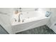 Close up on the bathroom soaking tub, with marble walls and tile floor at 238 Knob Hill Dr, Locust Grove, GA 30248