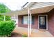 Inviting front porch with brick facade, black shutters, and a decorative glass front door at 238 Knob Hill Dr, Locust Grove, GA 30248