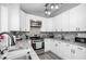 Well-lit kitchen features granite countertops, stainless appliances, and updated cabinetry at 238 Knob Hill Dr, Locust Grove, GA 30248