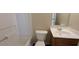 Well-lit bathroom with a toilet, vanity, and tub with tile surround at 2432 Pendergrass Ln, Ellenwood, GA 30294