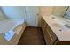 Bright bathroom with double vanity, soaking tub and wood-look flooring at 2432 Pendergrass Ln, Ellenwood, GA 30294