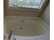 An inviting tub in the bathroom, illuminated by natural light at 2432 Pendergrass Ln, Ellenwood, GA 30294