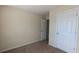 A carpeted room with neutral walls and white doors at 2432 Pendergrass Ln, Ellenwood, GA 30294