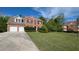 Two story brick home featuring an attached two car garage, black shutters and a large lawn at 2432 Pendergrass Ln, Ellenwood, GA 30294