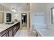 Luxurious primary bathroom featuring dual sinks, soaking tub, and walk-in shower, designed for relaxation at 4155 Winterberry Rd, Cumming, GA 30040